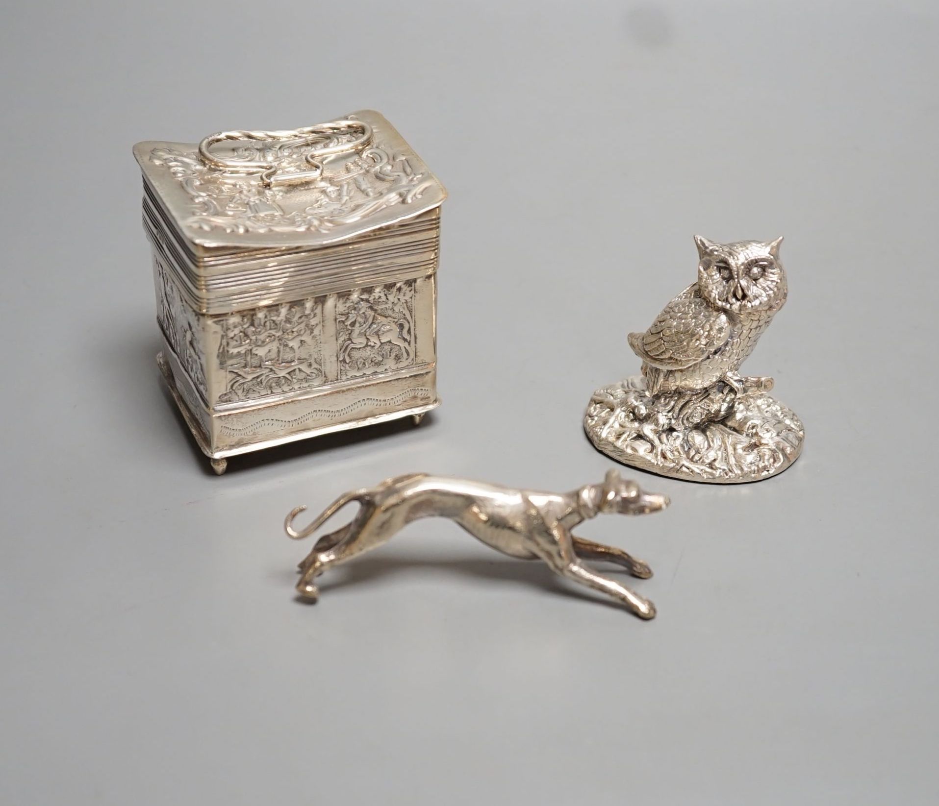 A continental embossed silver box, with import marks for London, 1903, 65mm, a modern silver filled model owl and a metal model of a dog.